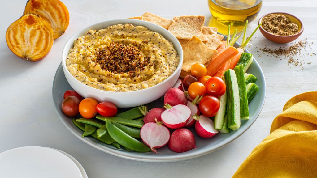 golden-beet-hummus-served-with-vegetable-sticks-and-topped-with-quinoa-and-arugula
