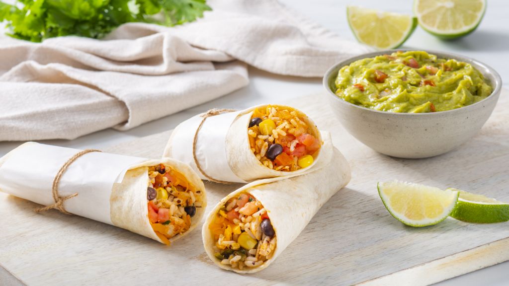 tex-mex-rice-and-beans-chicken-burrito-served-with-guacamole-and-lime-wedges