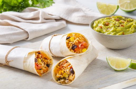 tex-mex-rice-and-beans-chicken-burrito-served-with-guacamole-and-lime-wedges